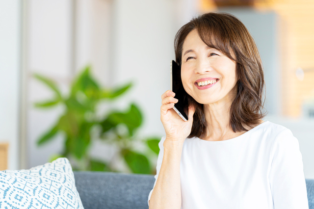 スマホで電話をしている中年の女性